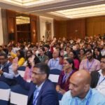 Attendees of Conversational AI & Customer Experience Summit Asia raising hands.